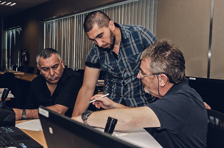 Team of professionals collaborating in an office setting, discussing strategies and reviewing documents to ensure effective planning and execution of operations