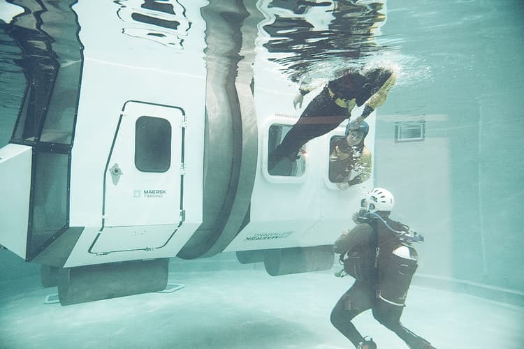Participants engaging in Helicopter Underwater Escape Training (HUET), simulating a submerged aircraft escape to improve safety and survival skills.
